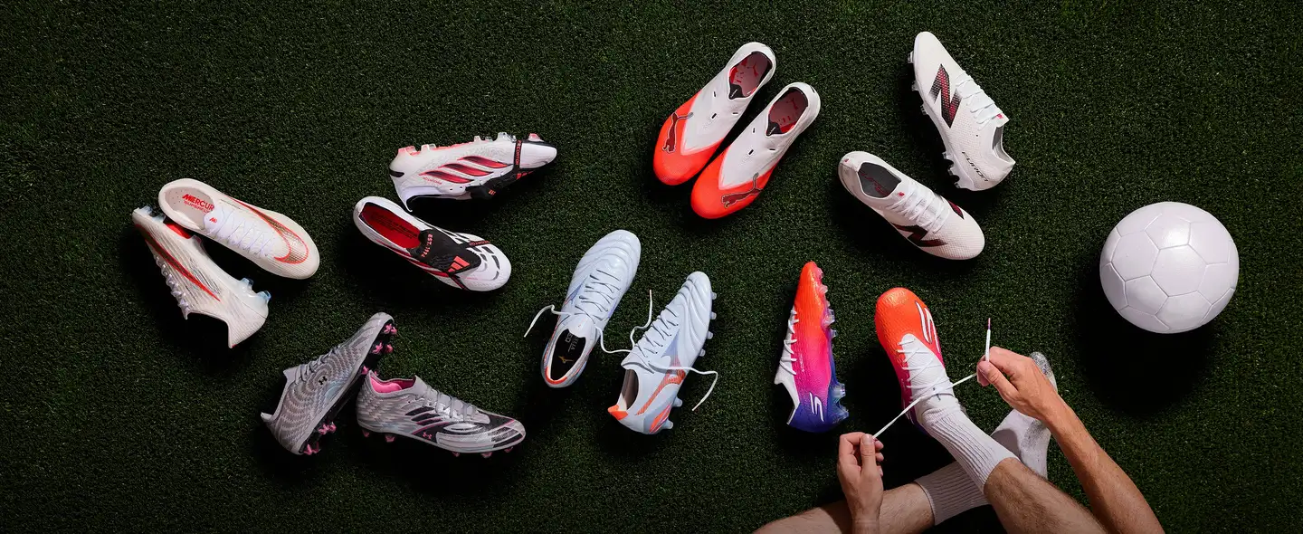 A selection of football boots laid out on the pitch